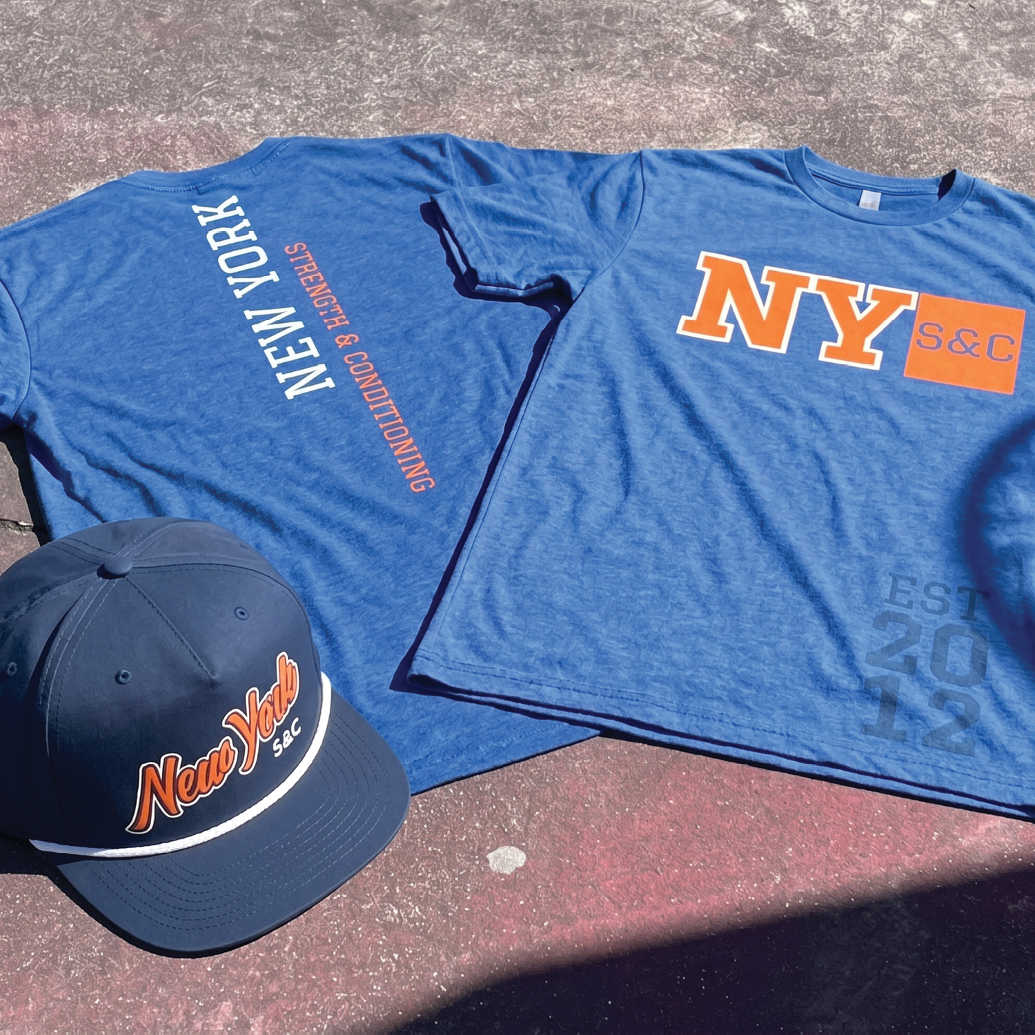 NY S&C blue apparel and hat flat lay