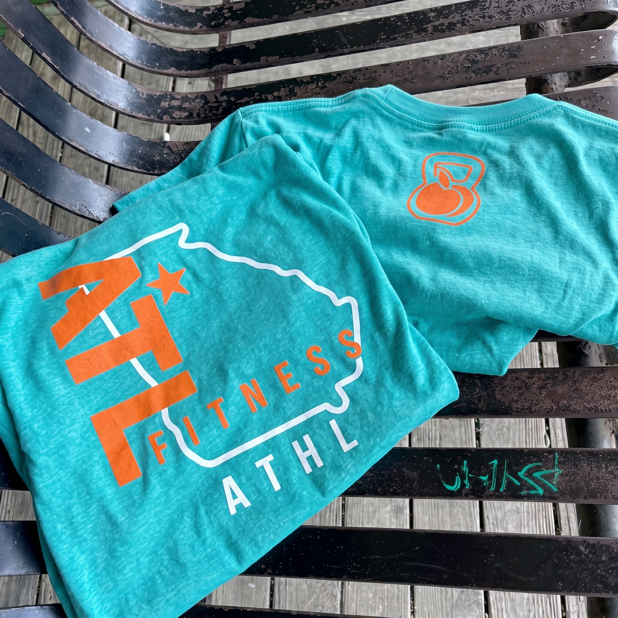 ATL Fitness aqua tee with Georgia outline and kettlebell peach mark