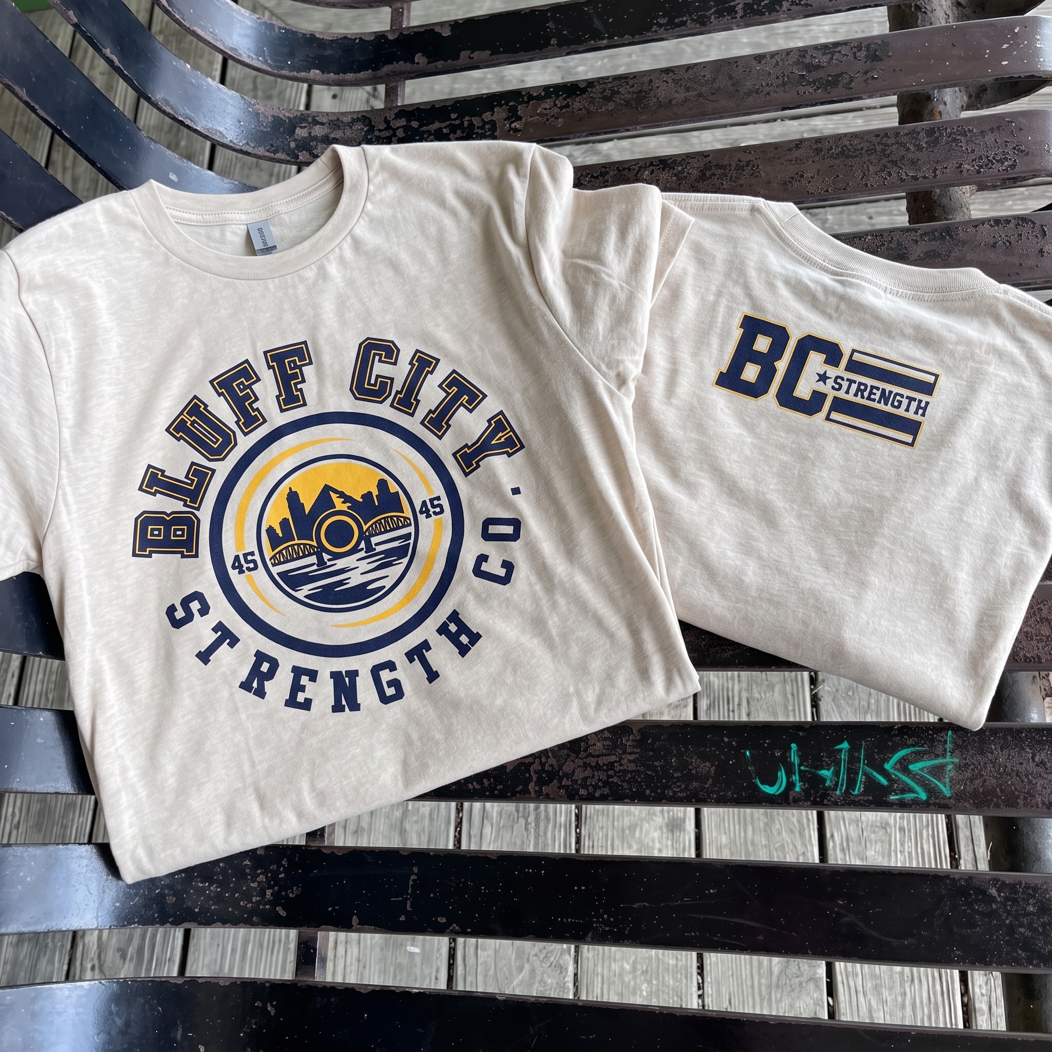 Bluff City Strength Co cream tee with river crest and BC Strength back mark