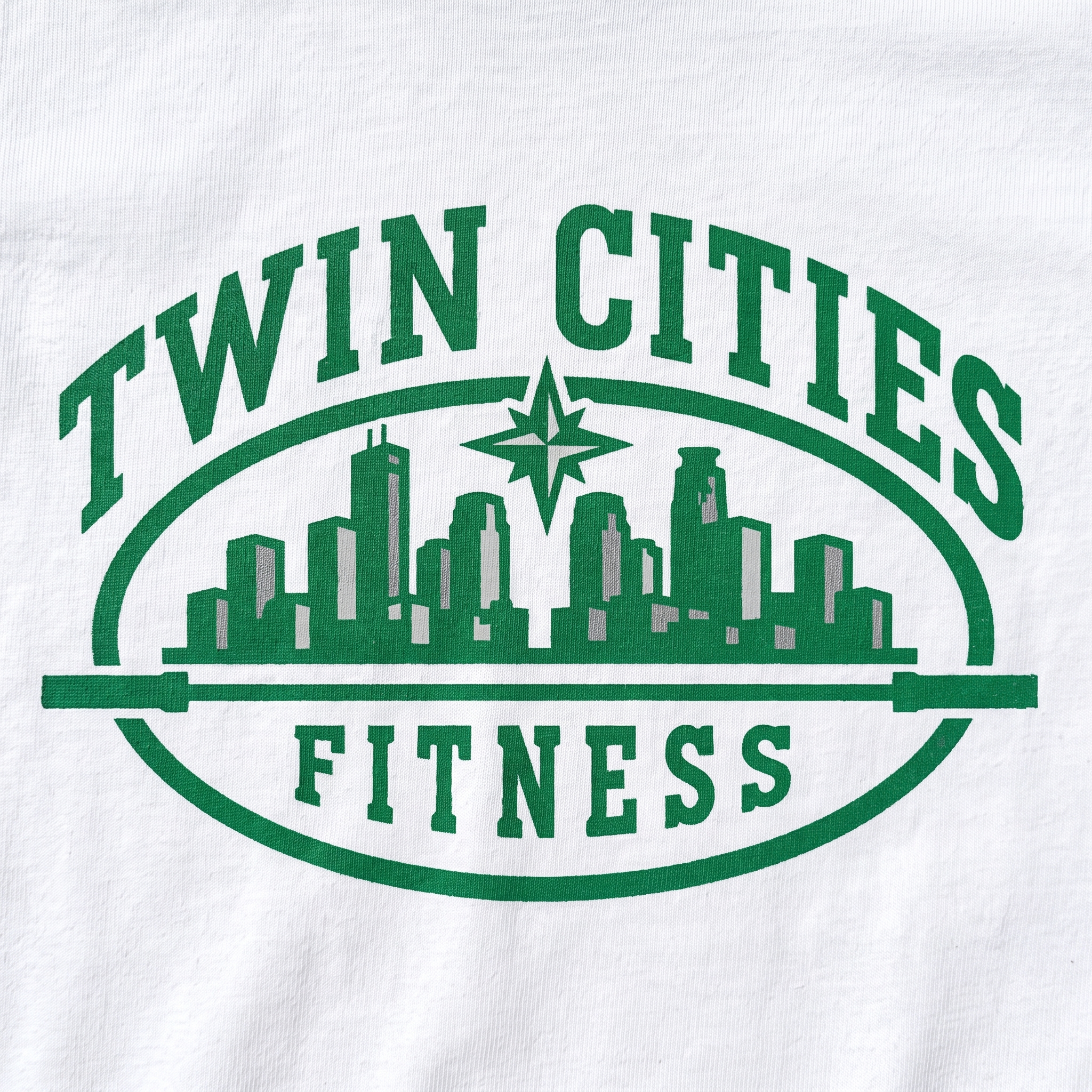 Twin Cities Fitness screen print logo detail with green skyline, barbell, North Star, and arched type