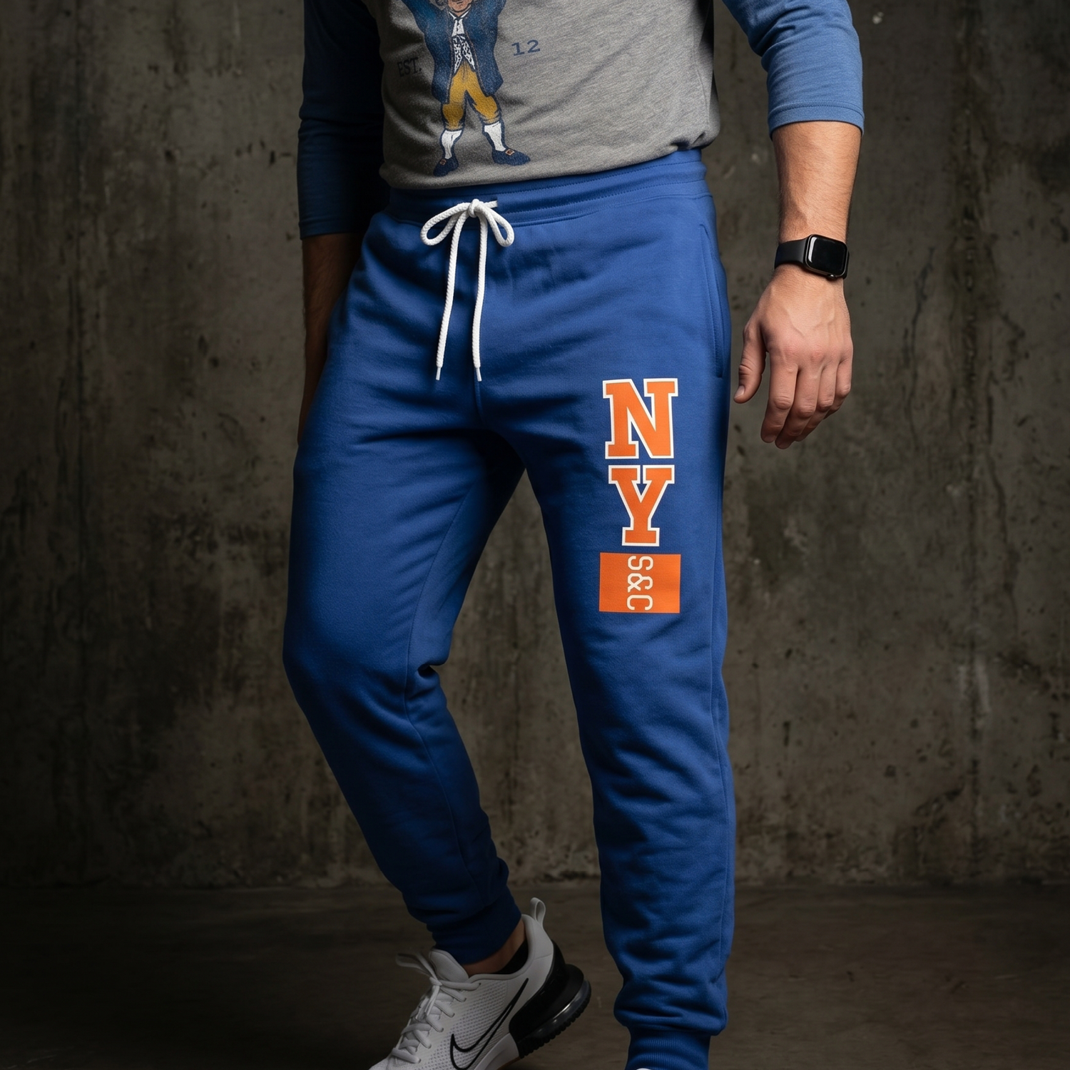 Athlete kneeling in blue New York Strength and Conditioning joggers with vertical NY S&C leg mark