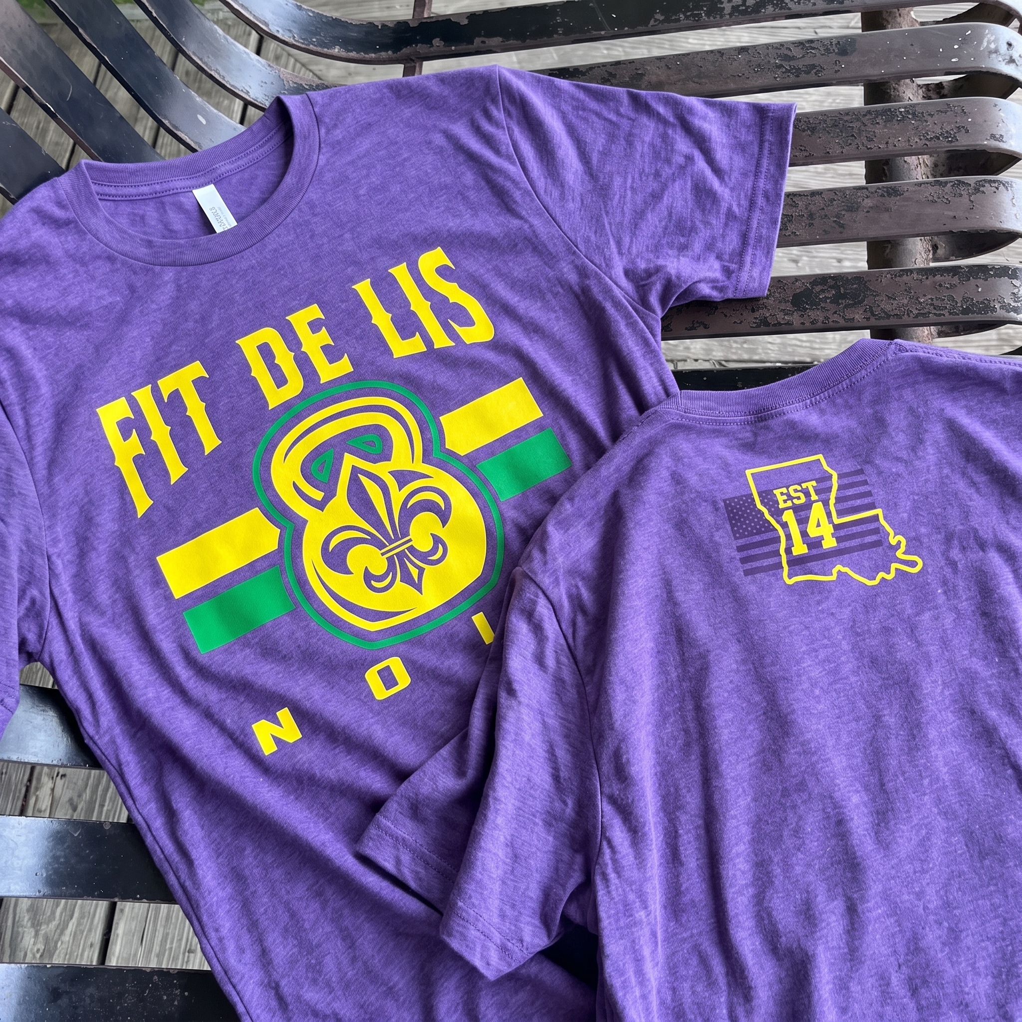 Purple Fit De Lis tee with front fleur-de-lis kettlebell graphic and back Louisiana EST 14 mark