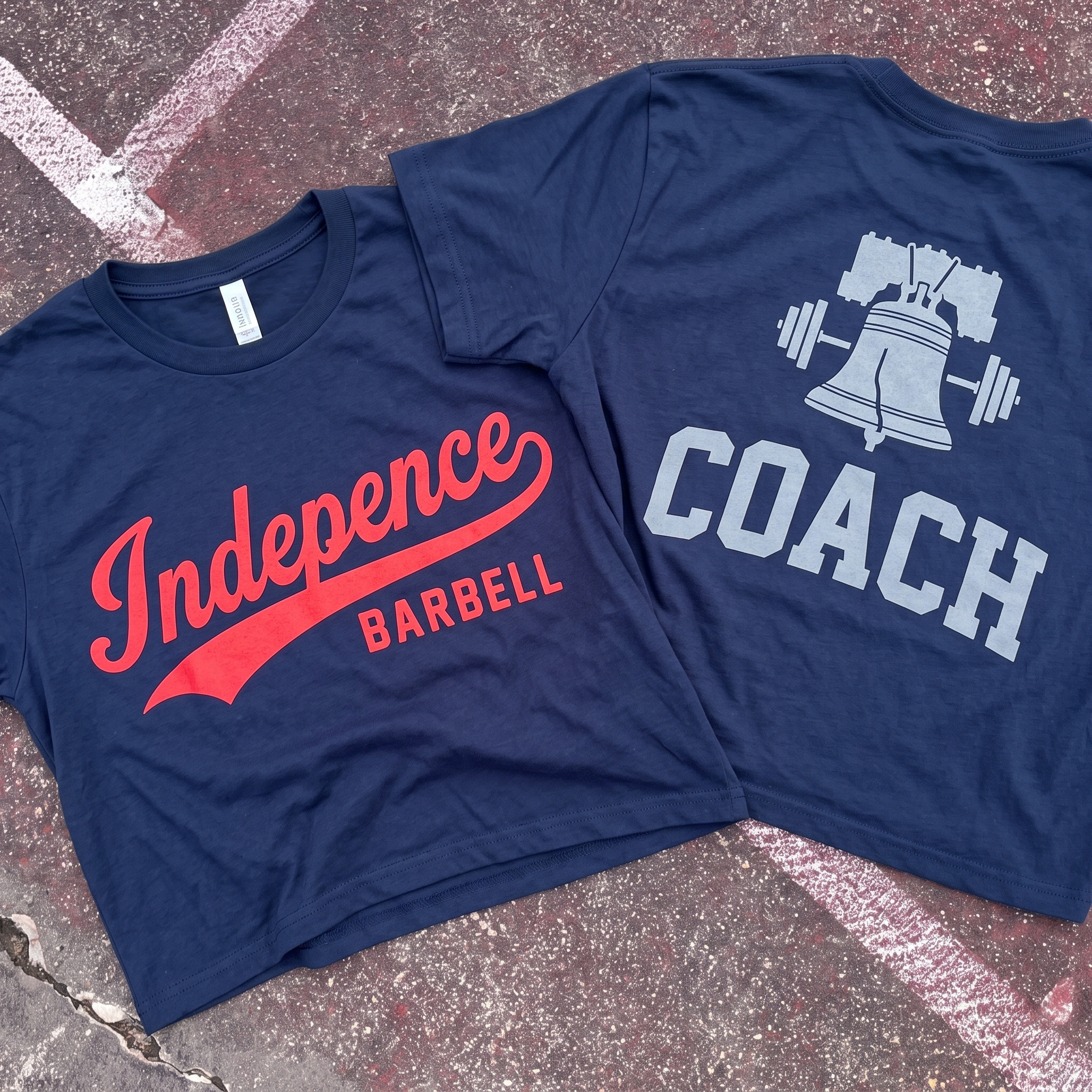 Independence Barbell full apparel lay flat with navy coach tee, cream ringer tee, red tee, gradient hoodie, black cap, and grey leggings