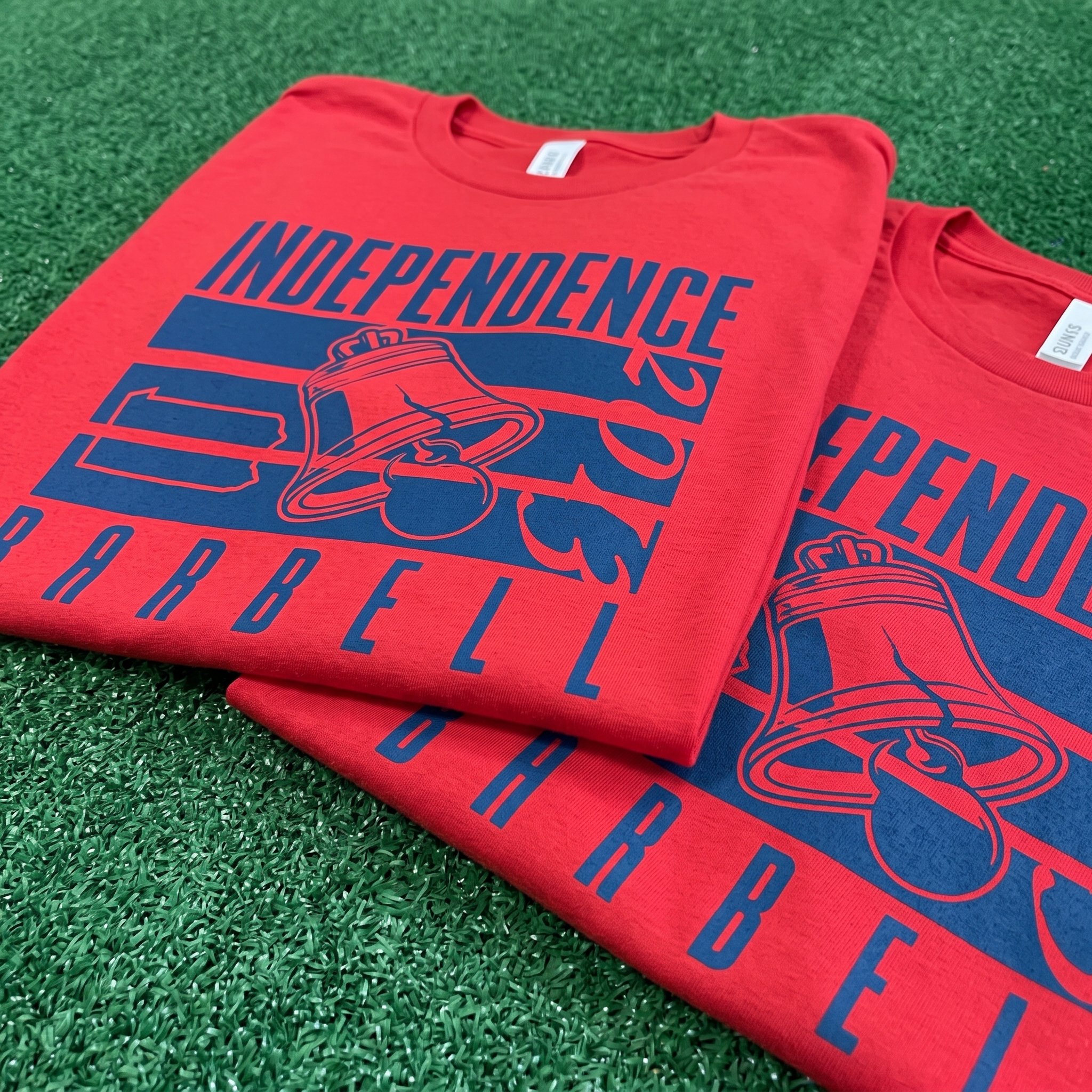 Navy Independence Barbell coach tee showing red script front and silver Liberty Bell coach back graphic
