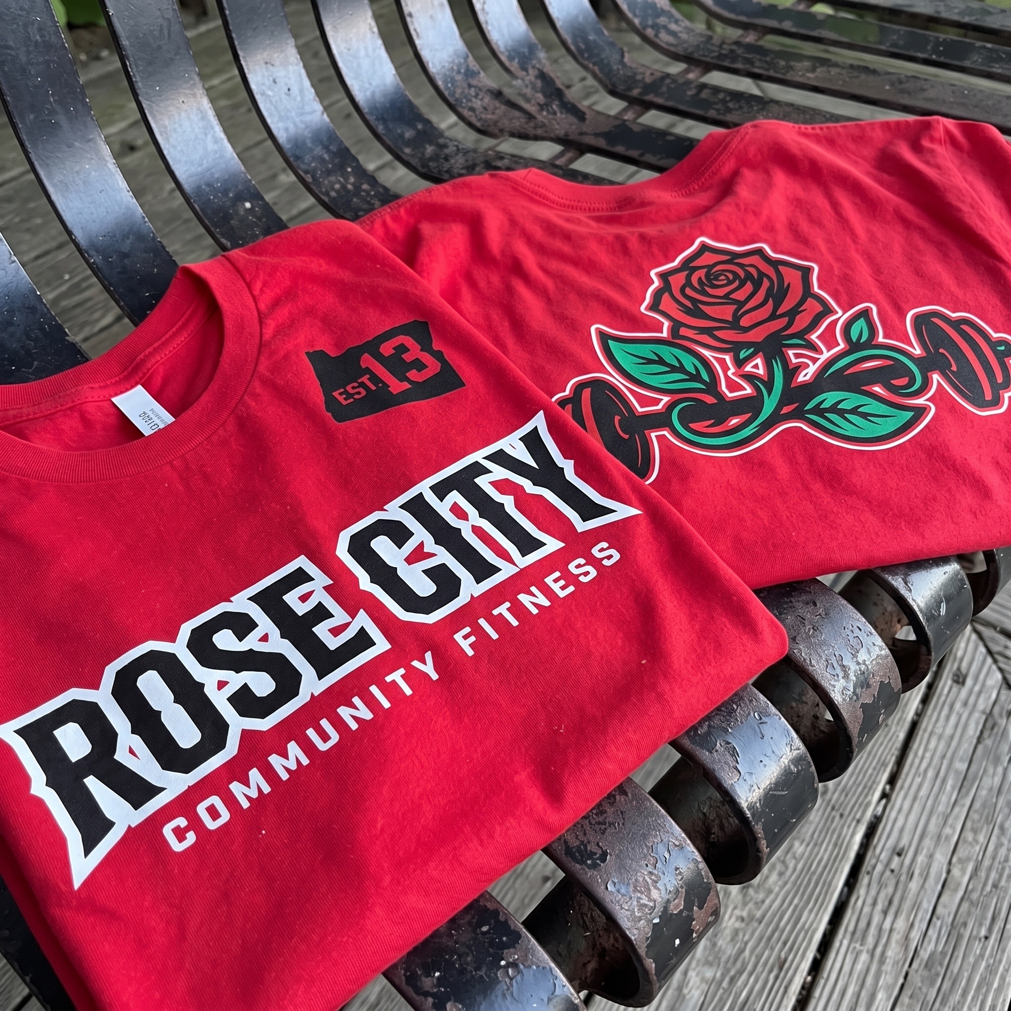 Red Rose City Community Fitness tee with bold block wordmark and rose barbell back graphic