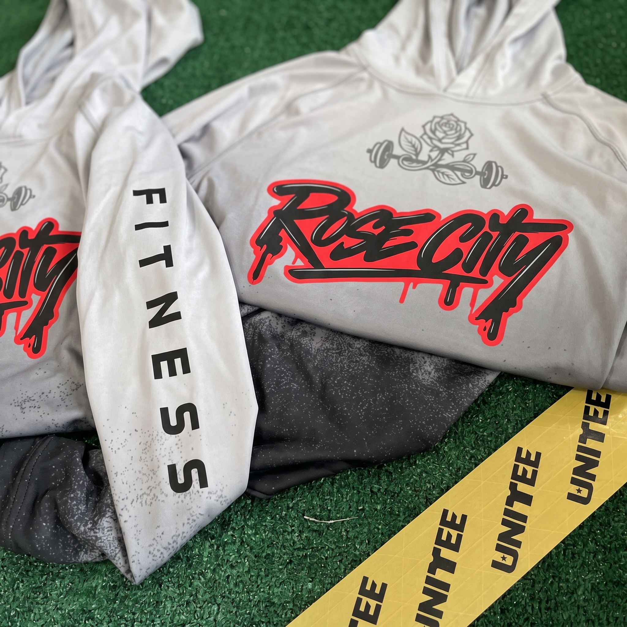White and grey Rose City Community Fitness hoodie with large red script logo and sleeve fitness type
