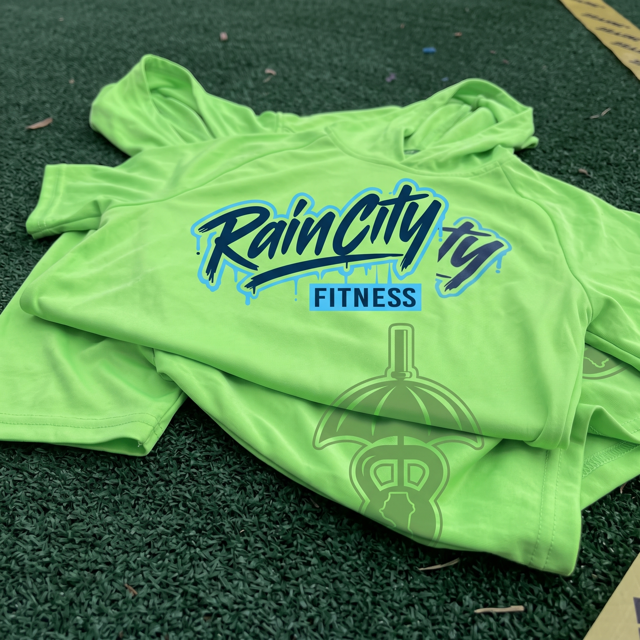 Neon green Rain City Fitness performance hoodie with script logo and umbrella kettlebell mark