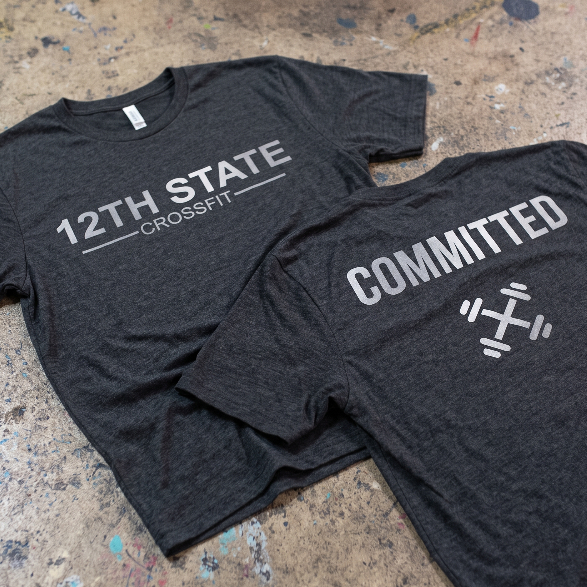Charcoal 12th State CrossFit tee with white front logo and Committed barbell back print.