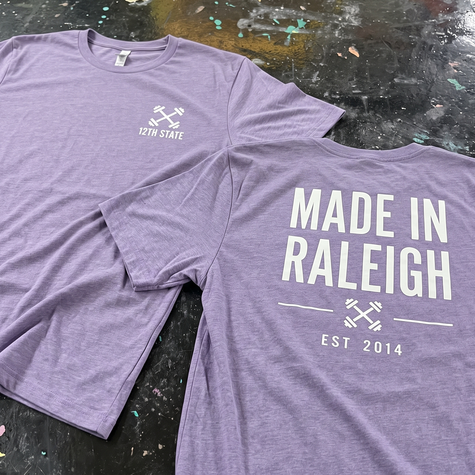 Lavender T-shirts with white 12th State chest marks and a large Made in Raleigh back print.