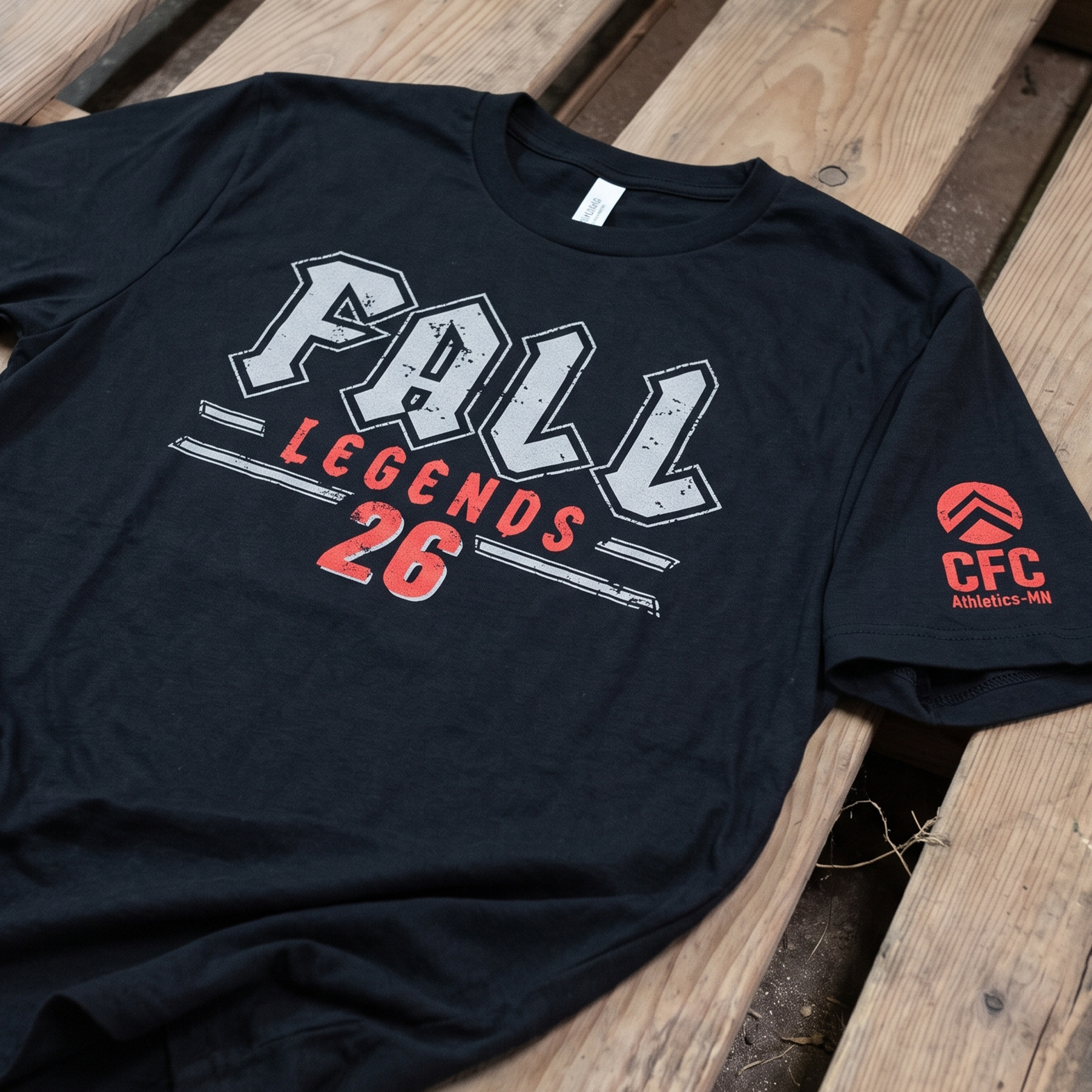 Close-up of black CFC Athletics Legends 26 shirt with distressed collegiate lettering and red sleeve logo.
