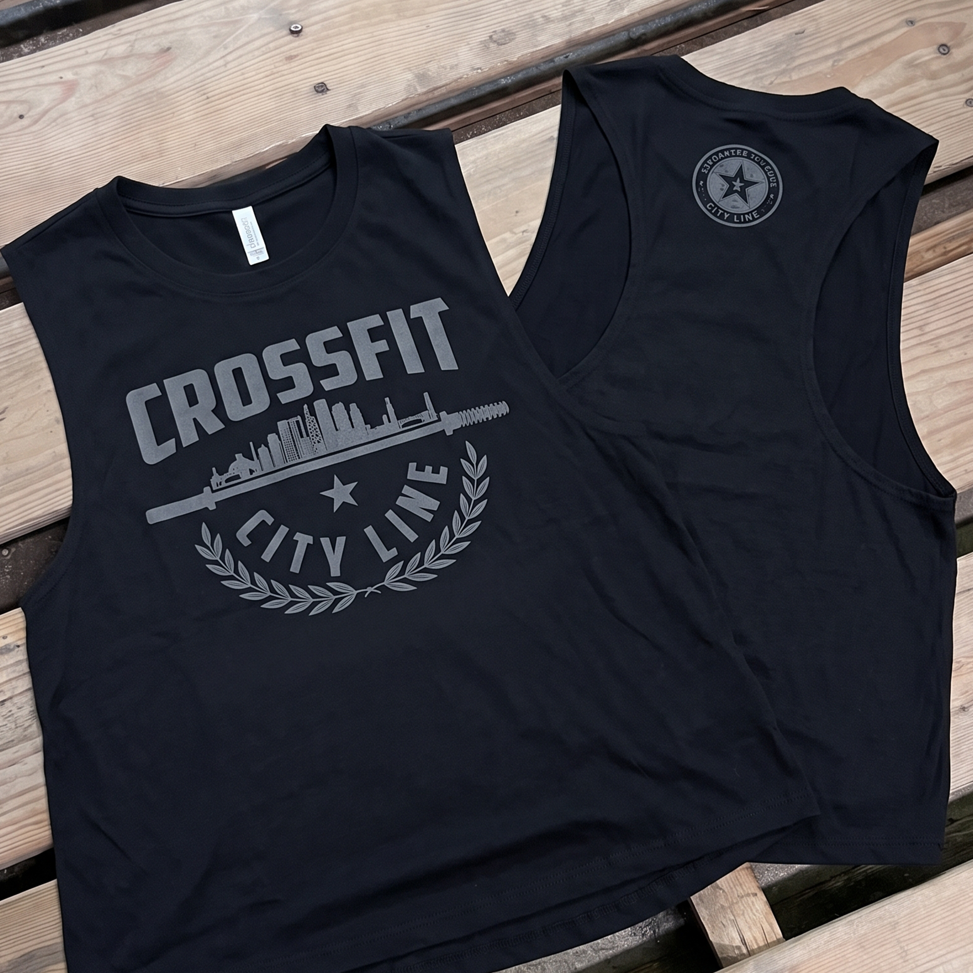 Black tank with gray CrossFit City Line skyline and barbell graphic beside a matching back logo tank.