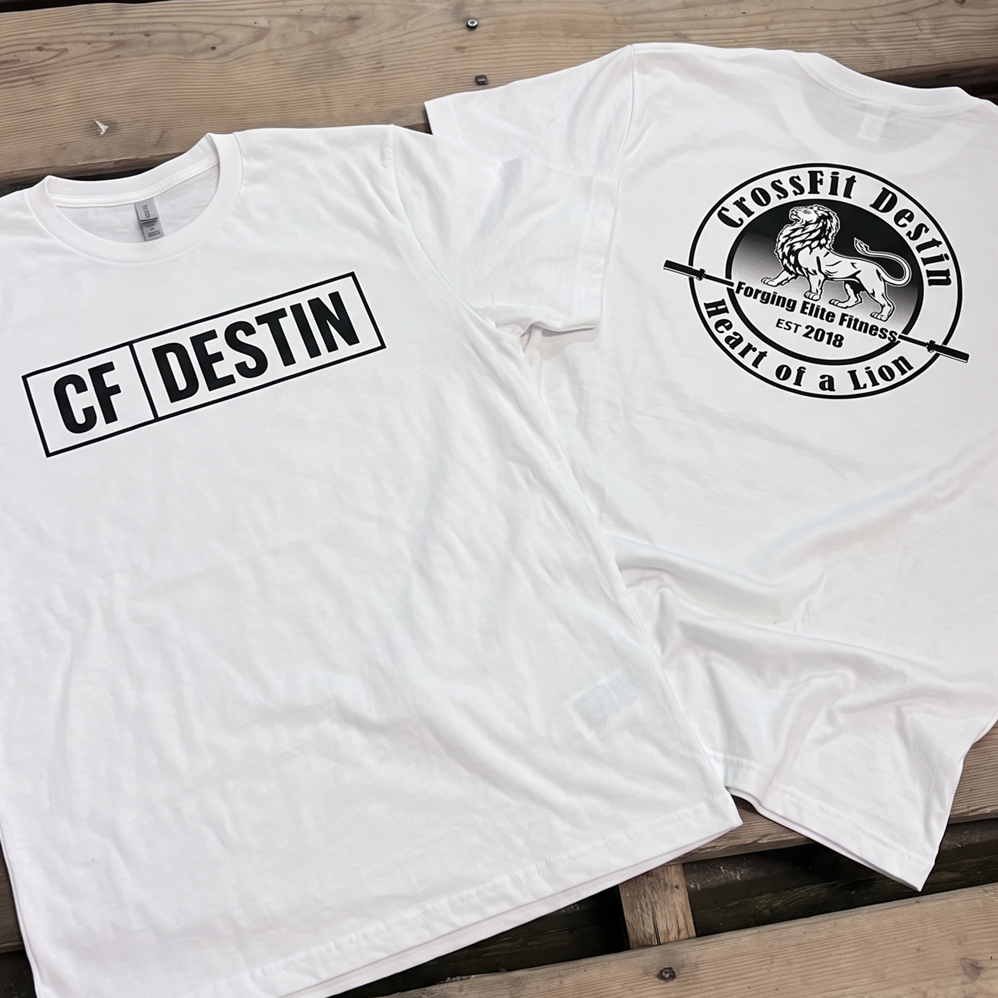 White CrossFit Destin tees with boxed front type and circular lion-and-barbell back print.
