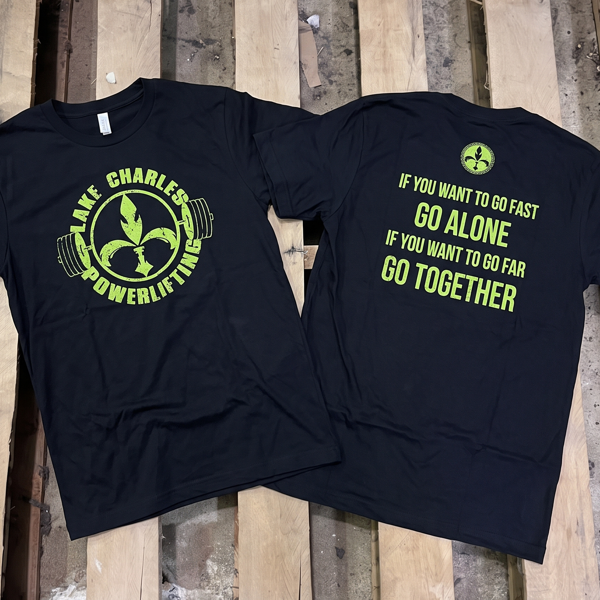 Black tees with neon-lime Lake Charles Powerlifting graphics and a motivational back quote.