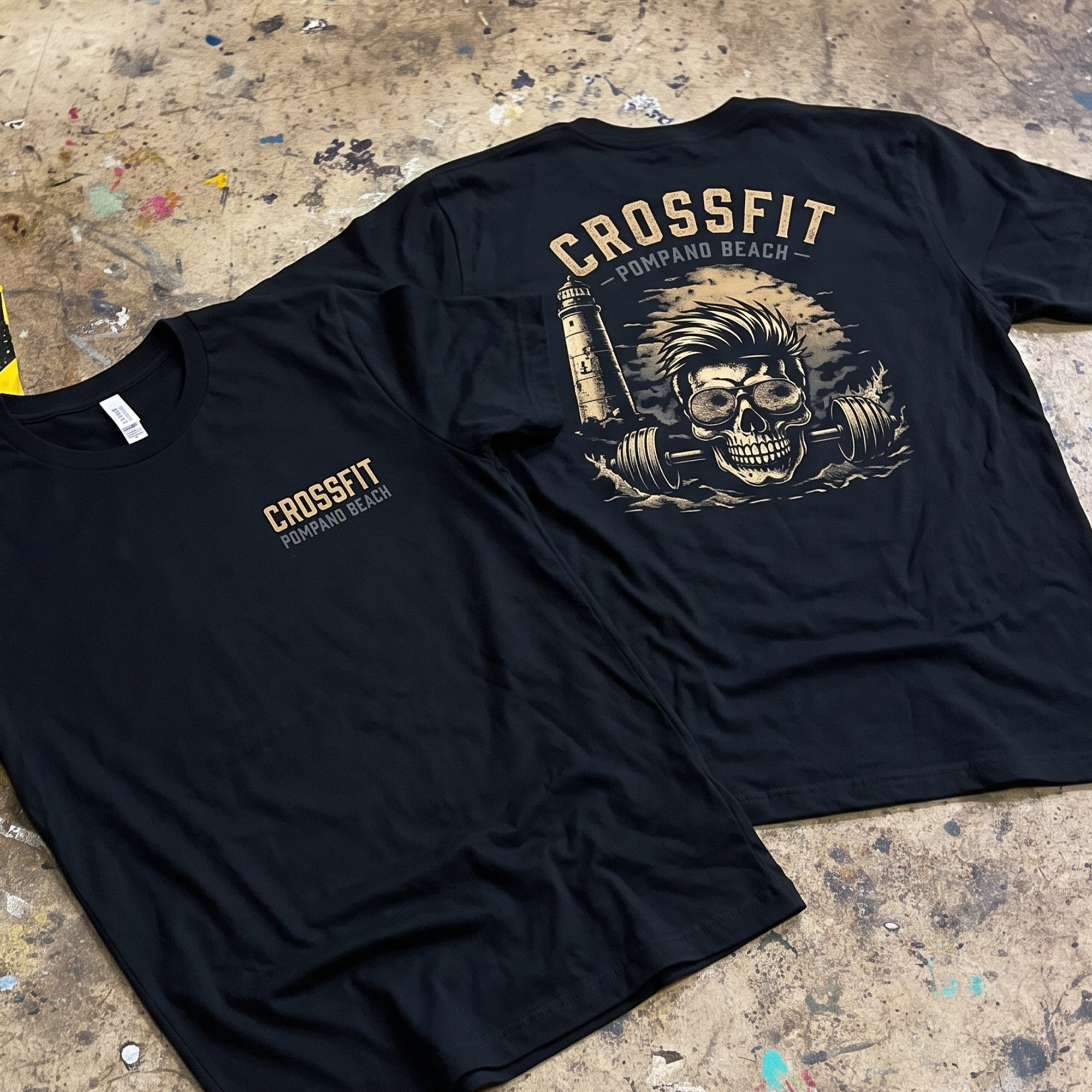 Black T-shirt with small front logo and large skull, barbell, and lighthouse back print.