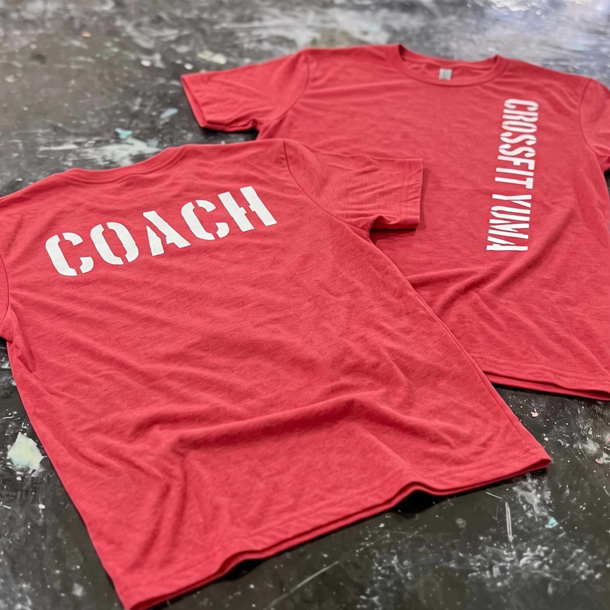Two red coach T-shirts with white COACH and vertical CrossFit Yuma prints.