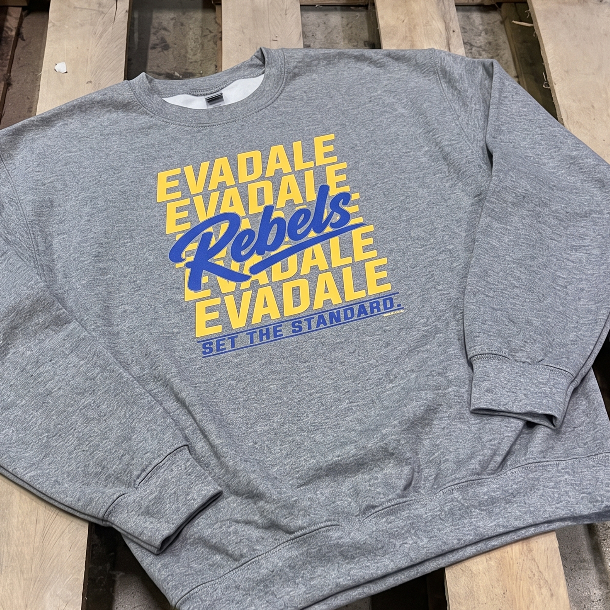 Heather gray crewneck sweatshirt with repeated gold Evadale lettering and blue Rebels script.