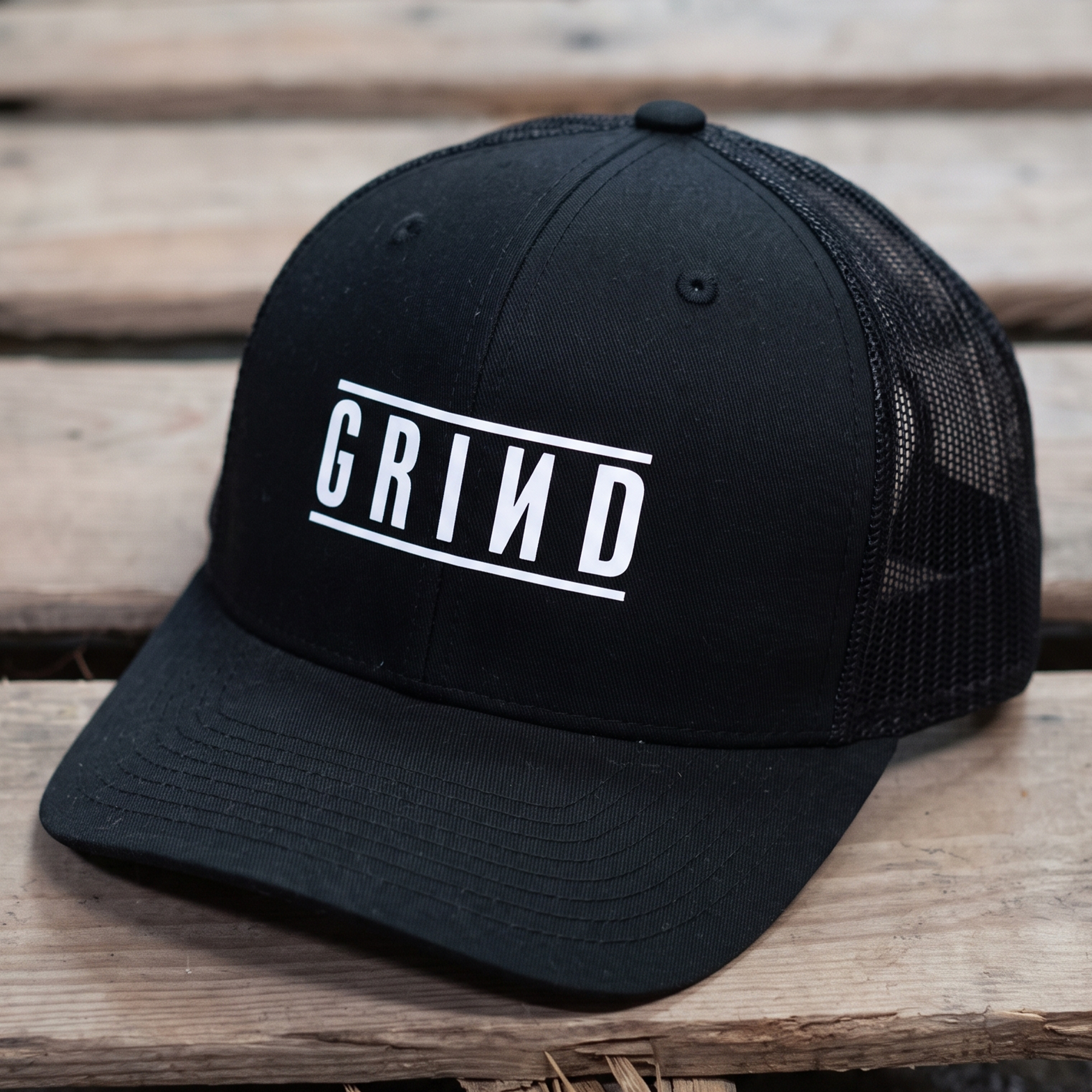 Black mesh trucker cap with white framed GRIND wordmark.