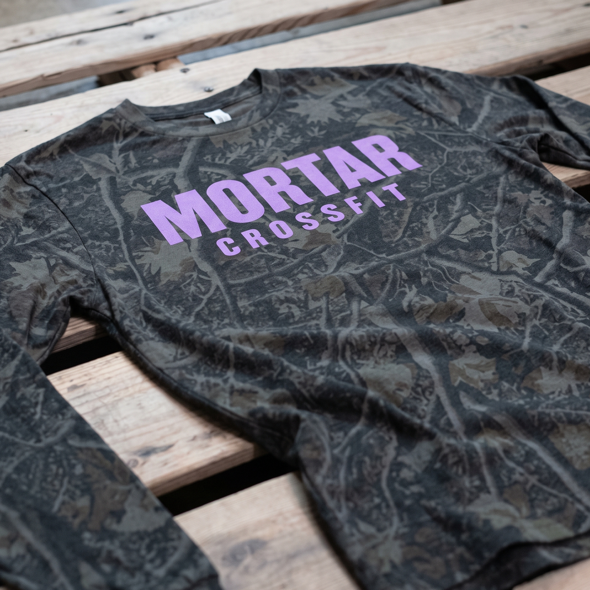 Dark tonal-camo Mortar CrossFit T-shirt with large lavender chest lettering.