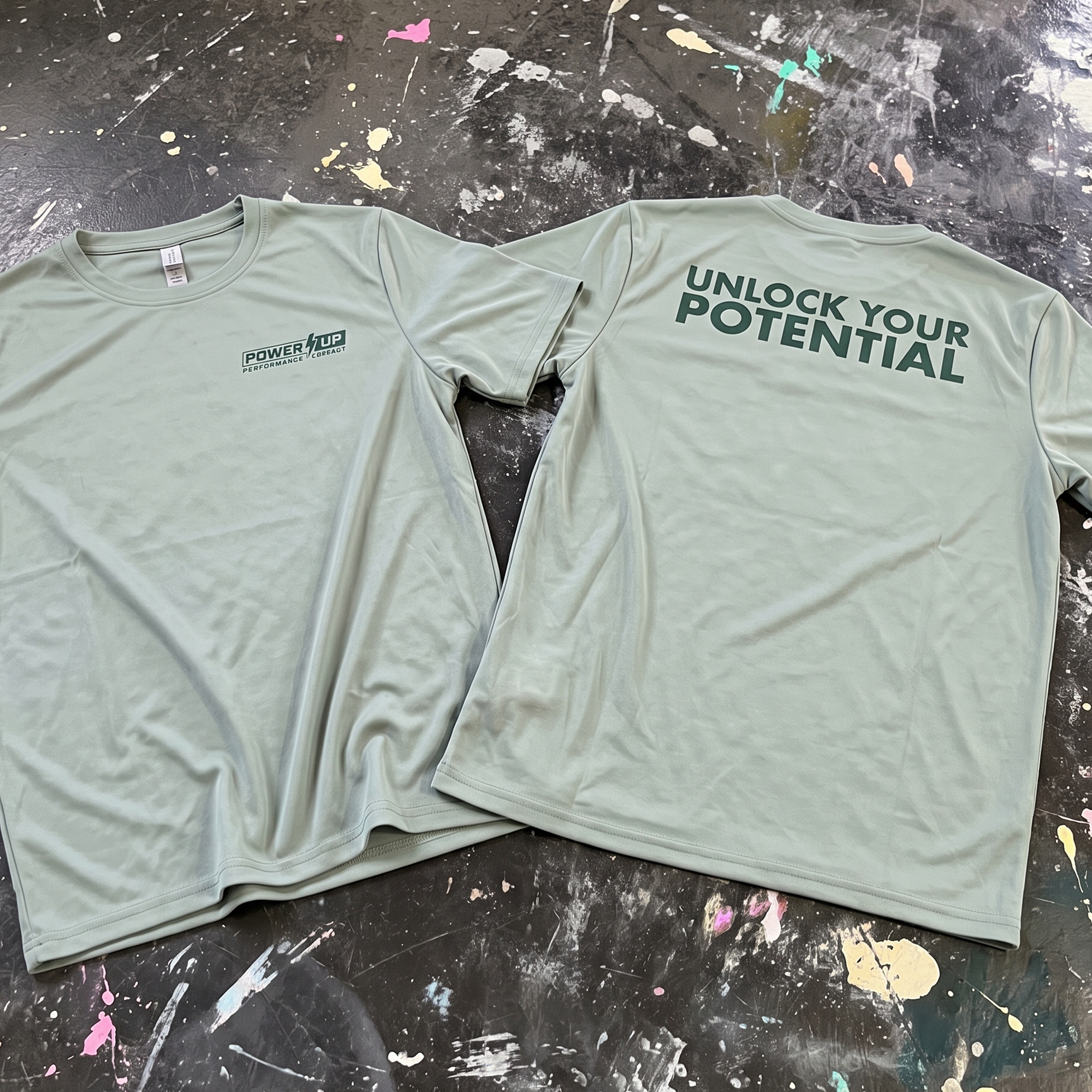Sage performance tees with a small Power Up chest logo and Unlock Your Potential back print.