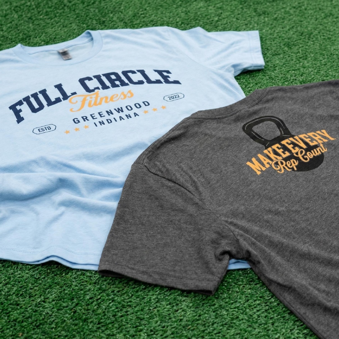 Light blue Full Circle Fitness tee and charcoal Make Every Rep Count kettlebell tee.