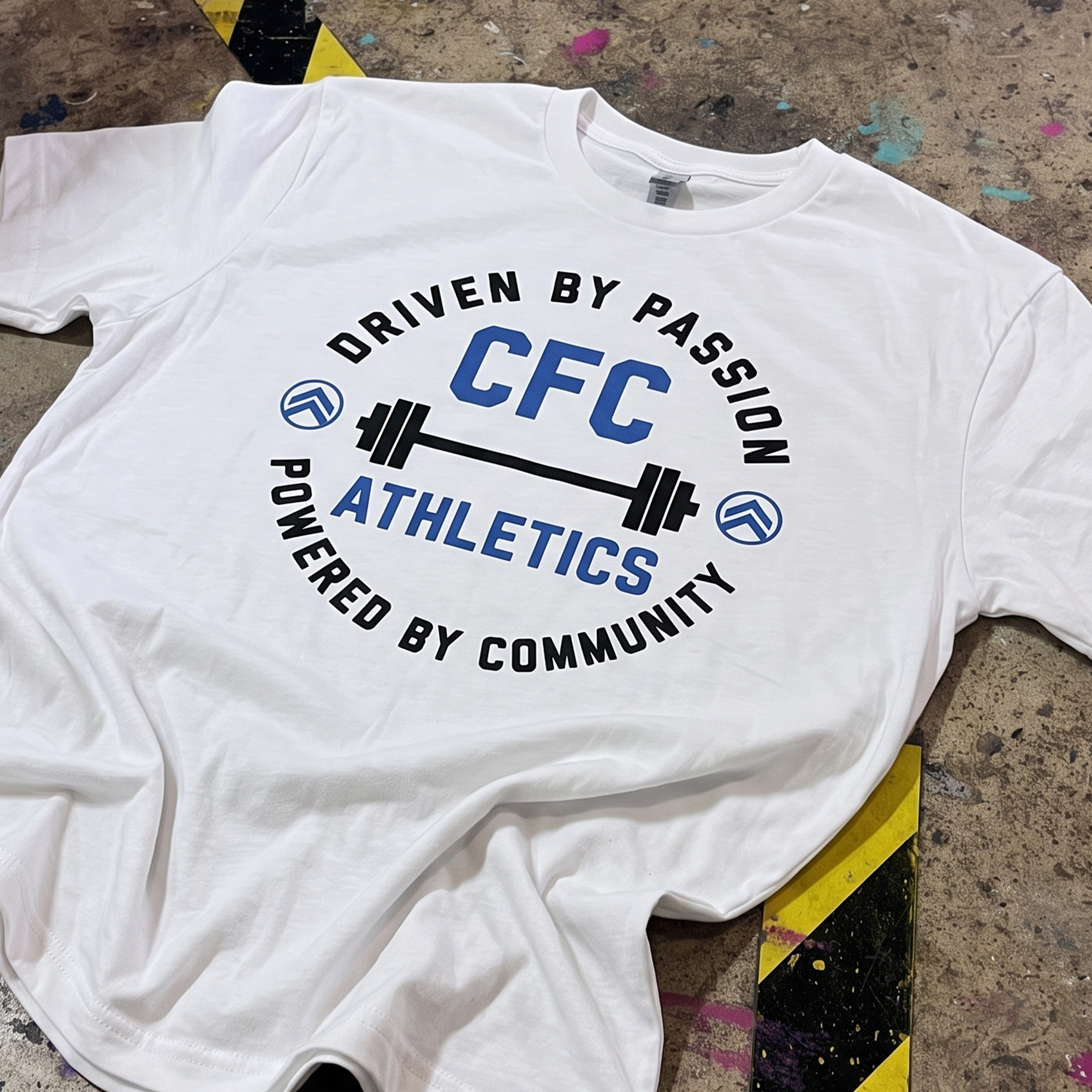 White CFC Athletics T-shirt with blue-and-black circular barbell graphic.