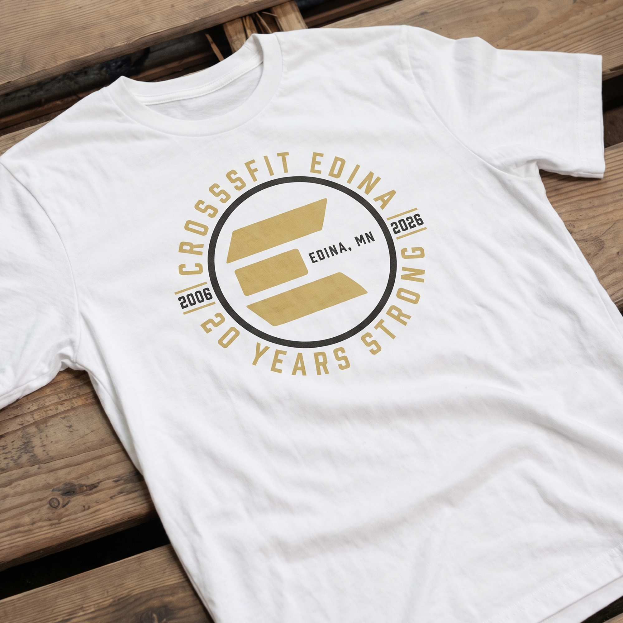 White T-shirt with gold and black CrossFit Edina 20 Years Strong anniversary graphic.