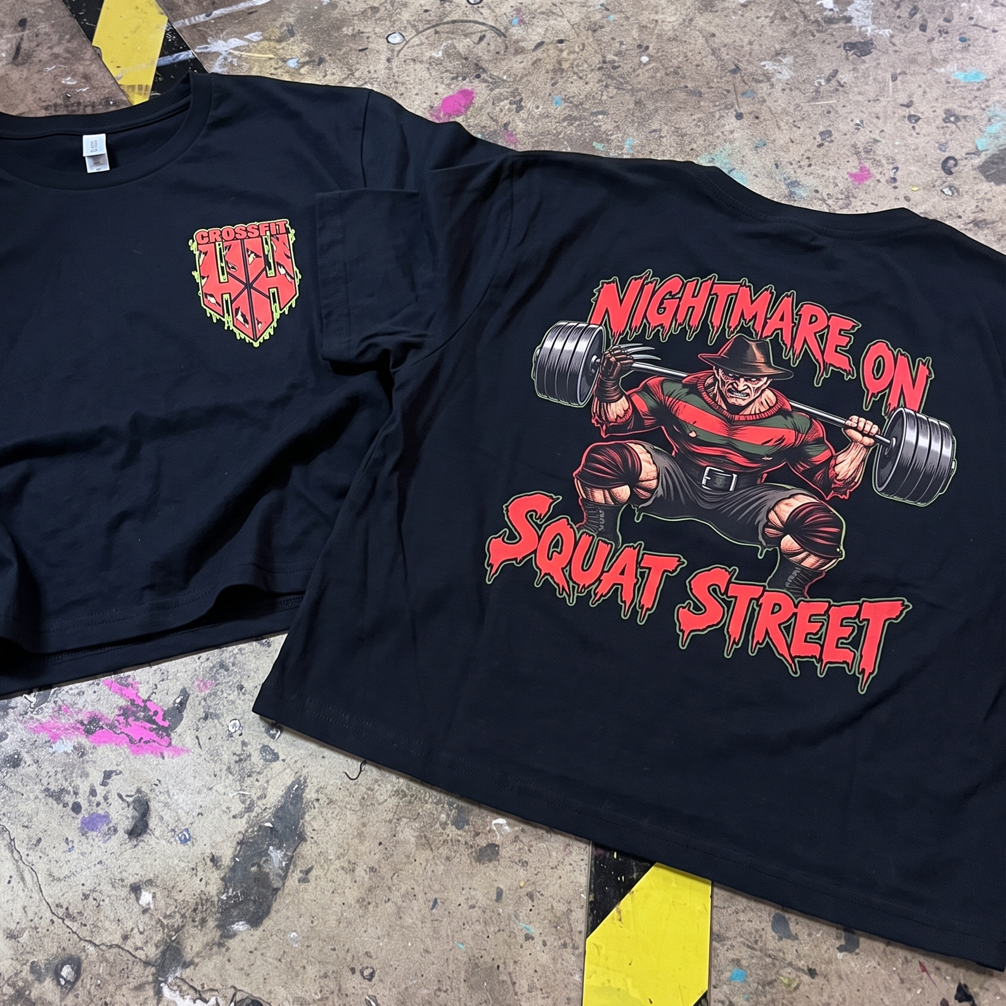 Black CrossFit Hoka Hey tees with a horror-style squatter back graphic and chest logo.