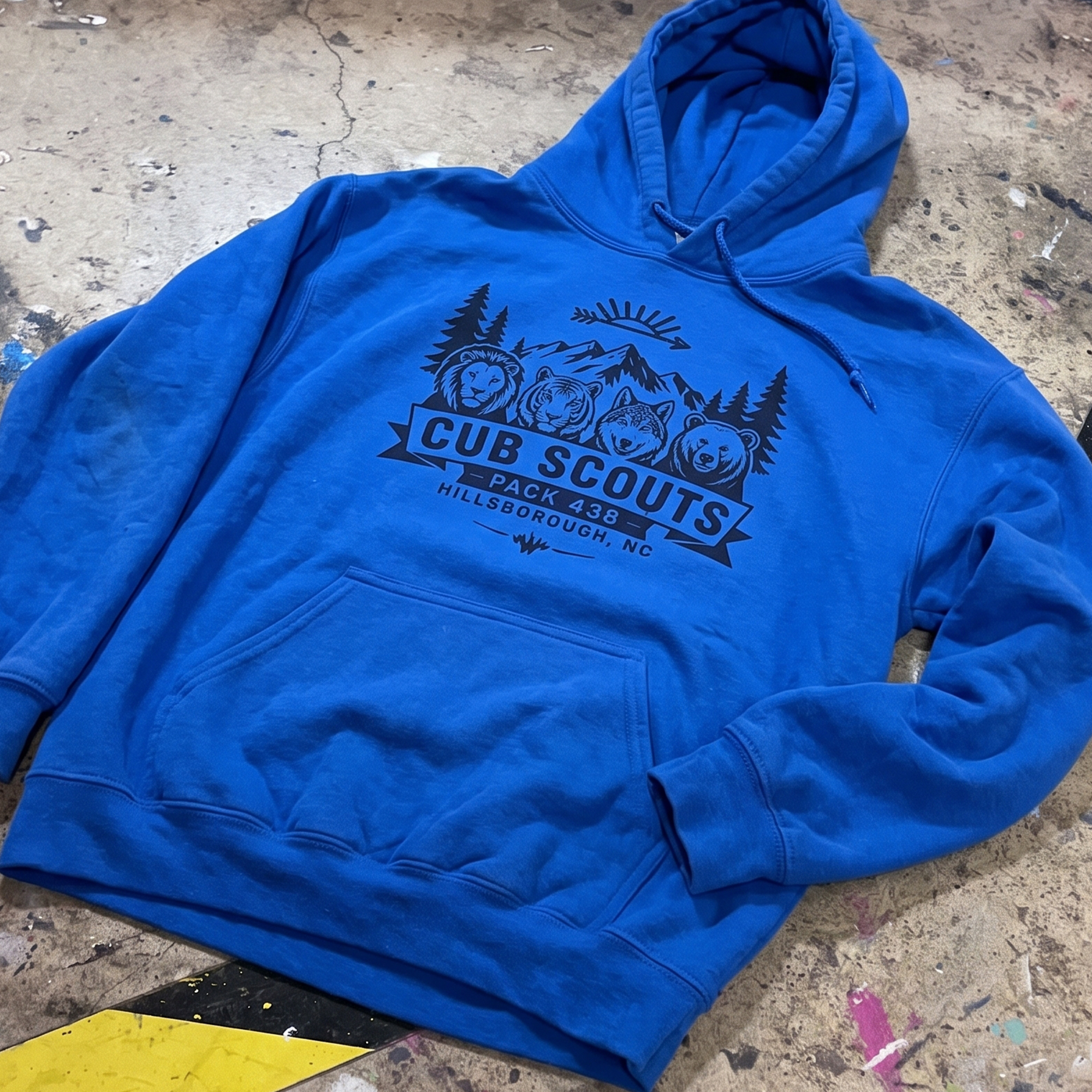 Royal blue hoodie with navy Cub Scouts Pack 438 mountain and animal graphic.