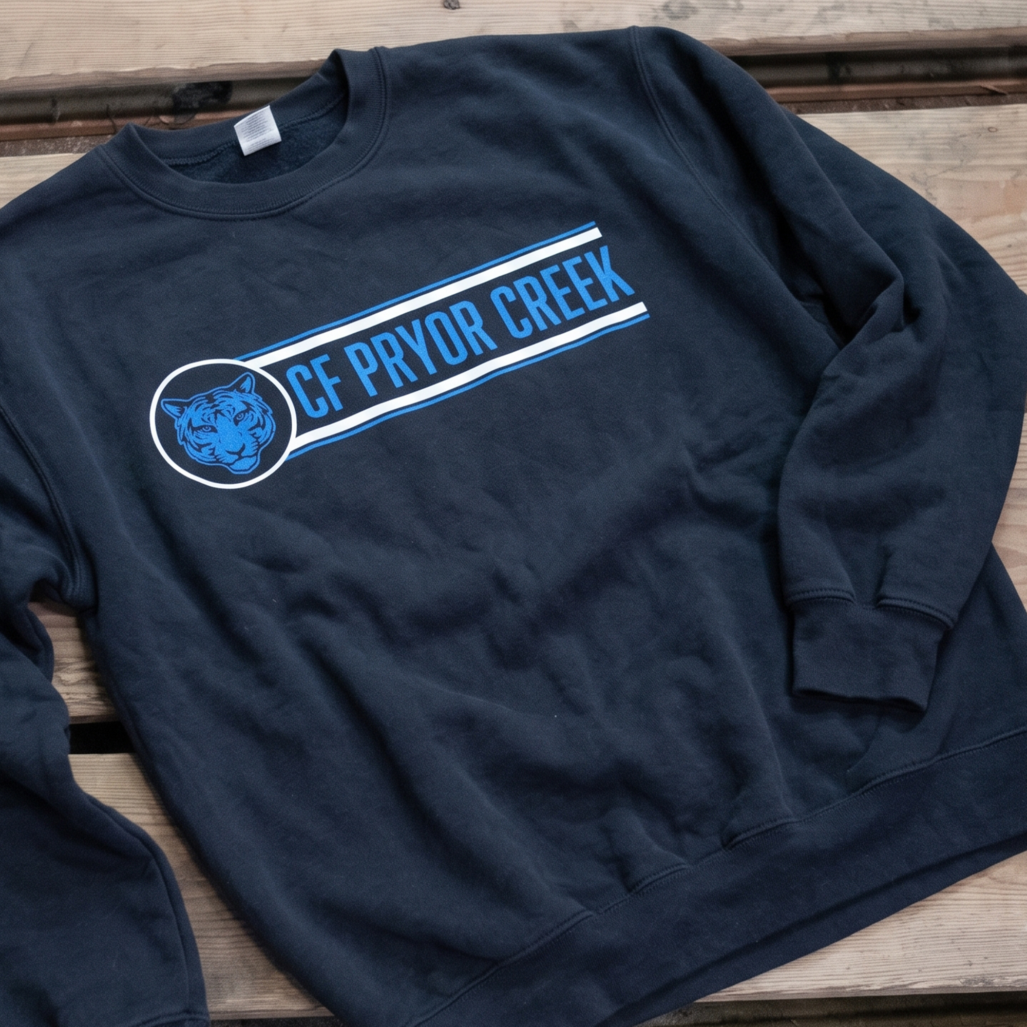 Black crewneck with blue tiger emblem and horizontal lettering.