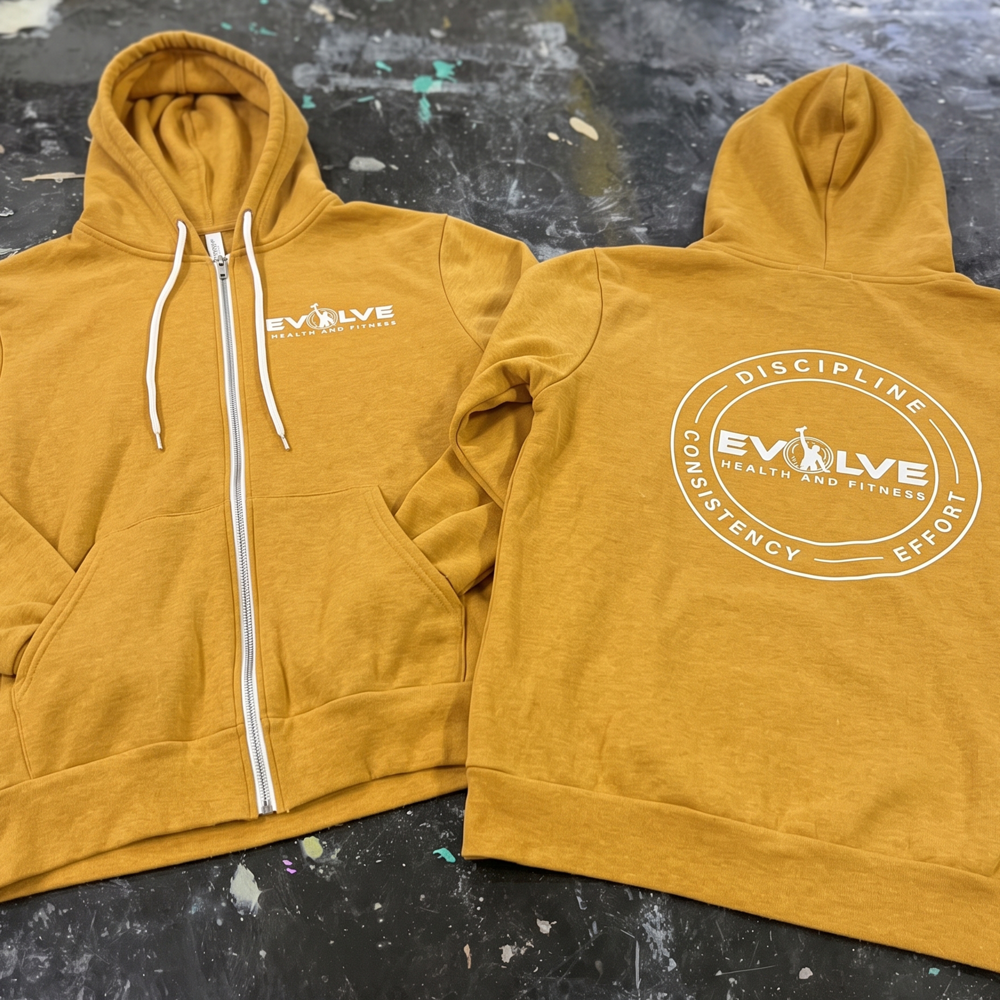 Mustard zip hoodies with white chest logo and circular back print.