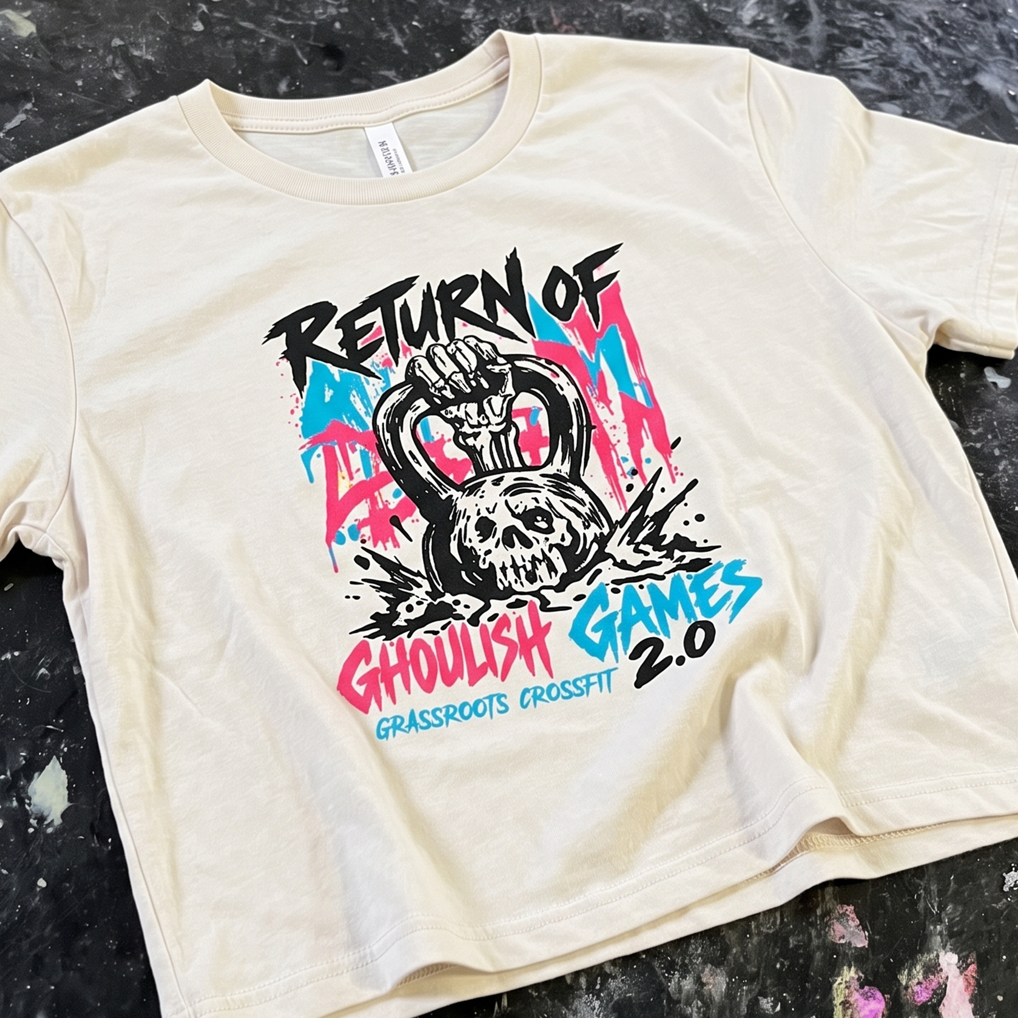 Cream tee with colorful Ghoulish Games 2.0 kettlebell skull print