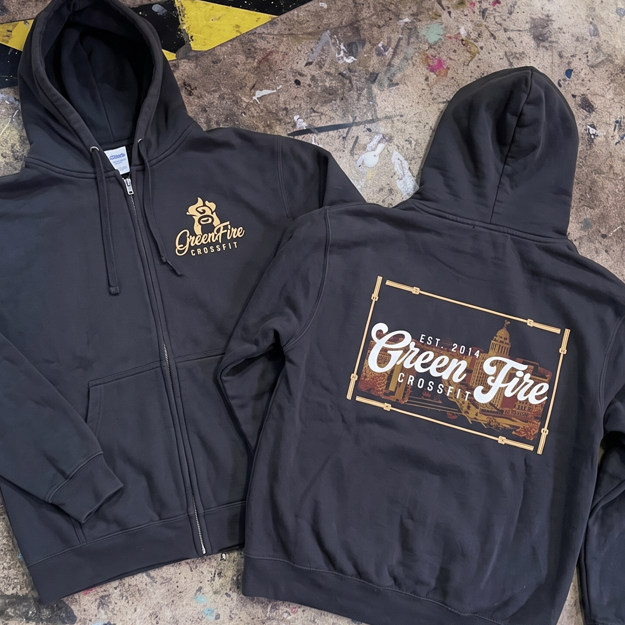 Black zip hoodies with small chest logo and cityscape back print.