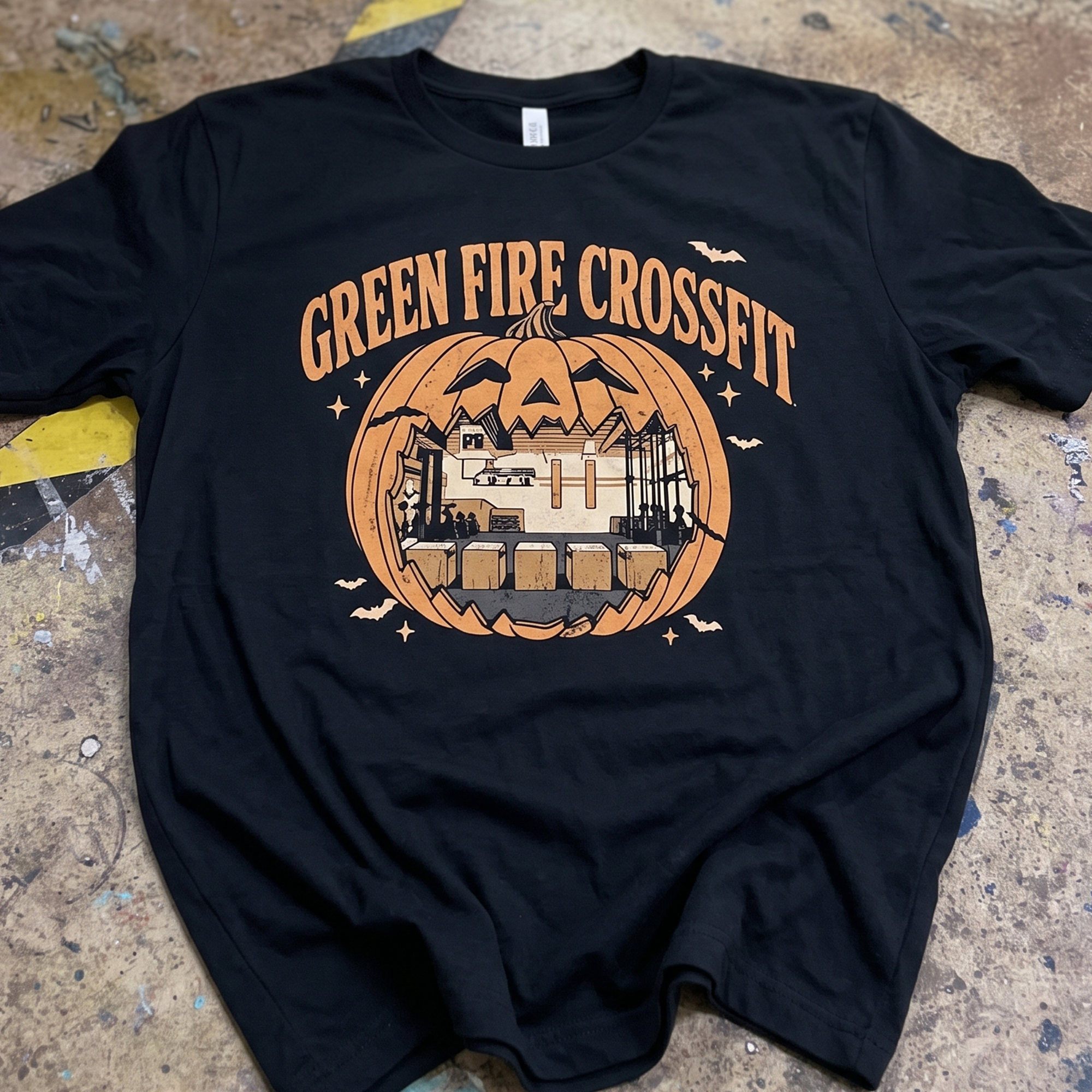 Black T-shirt with pumpkin-shaped gym illustration and Green Fire CrossFit lettering.