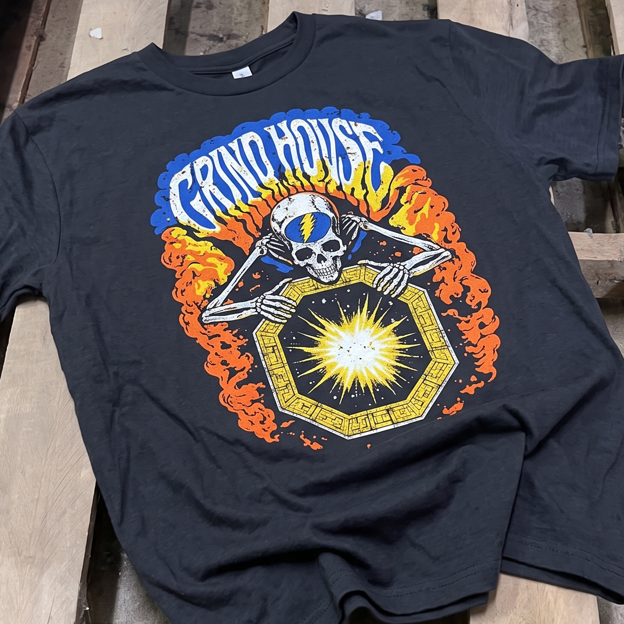 Black T-shirt with a colorful Grind House skull and starburst graphic