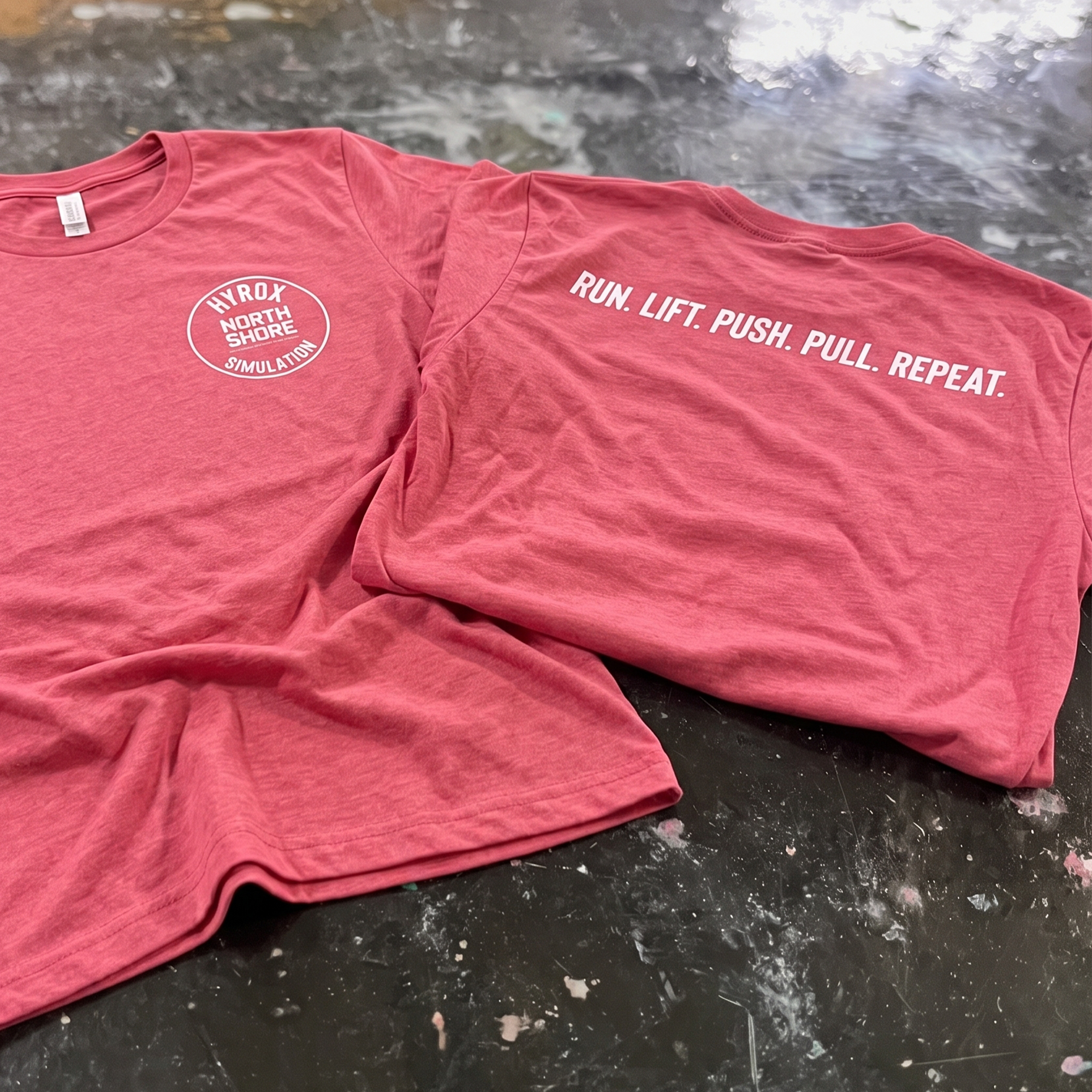 Coral tee with a white HYROX simulation chest badge and back slogan.