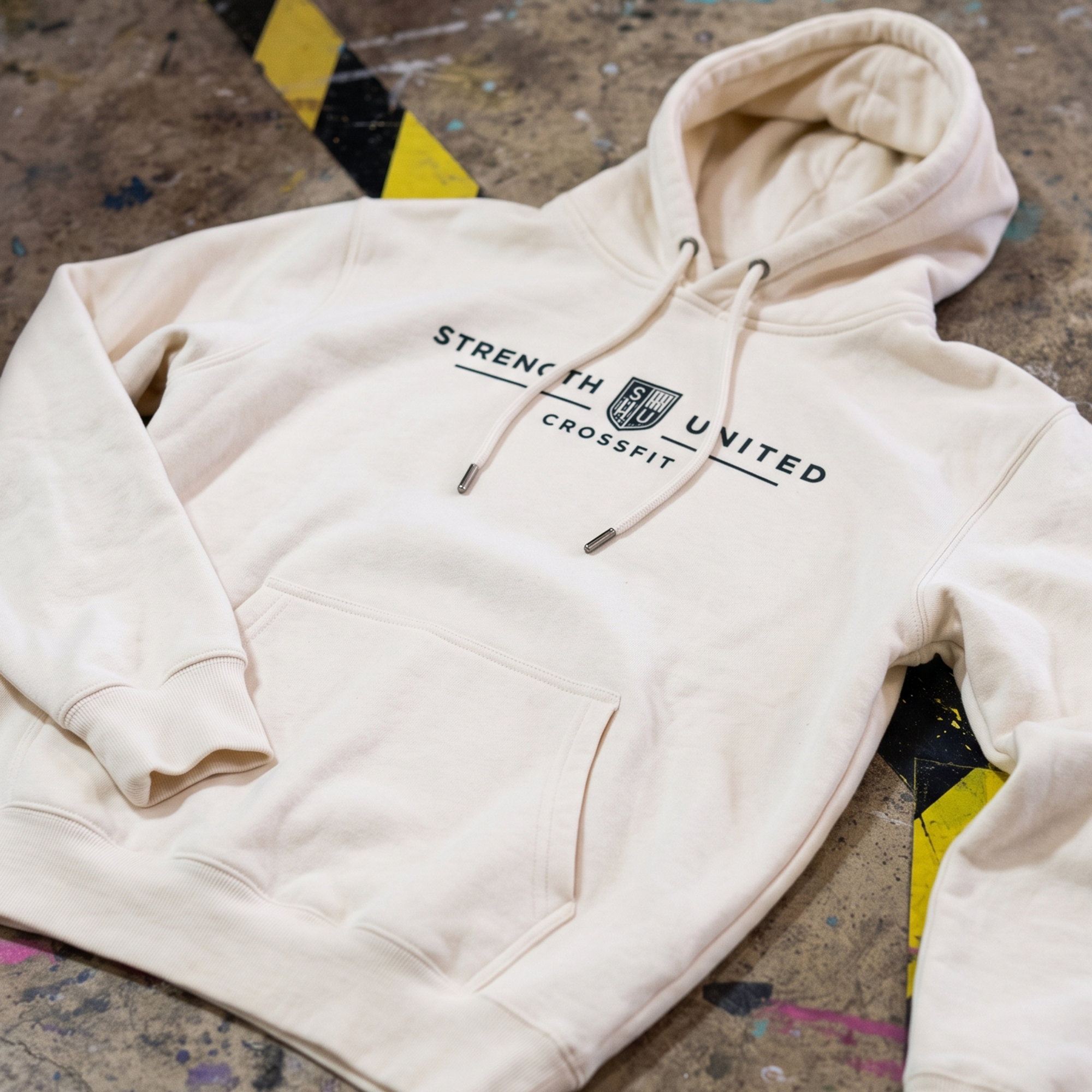 Cream hoodie with a centered Strength United CrossFit wordmark and crest.