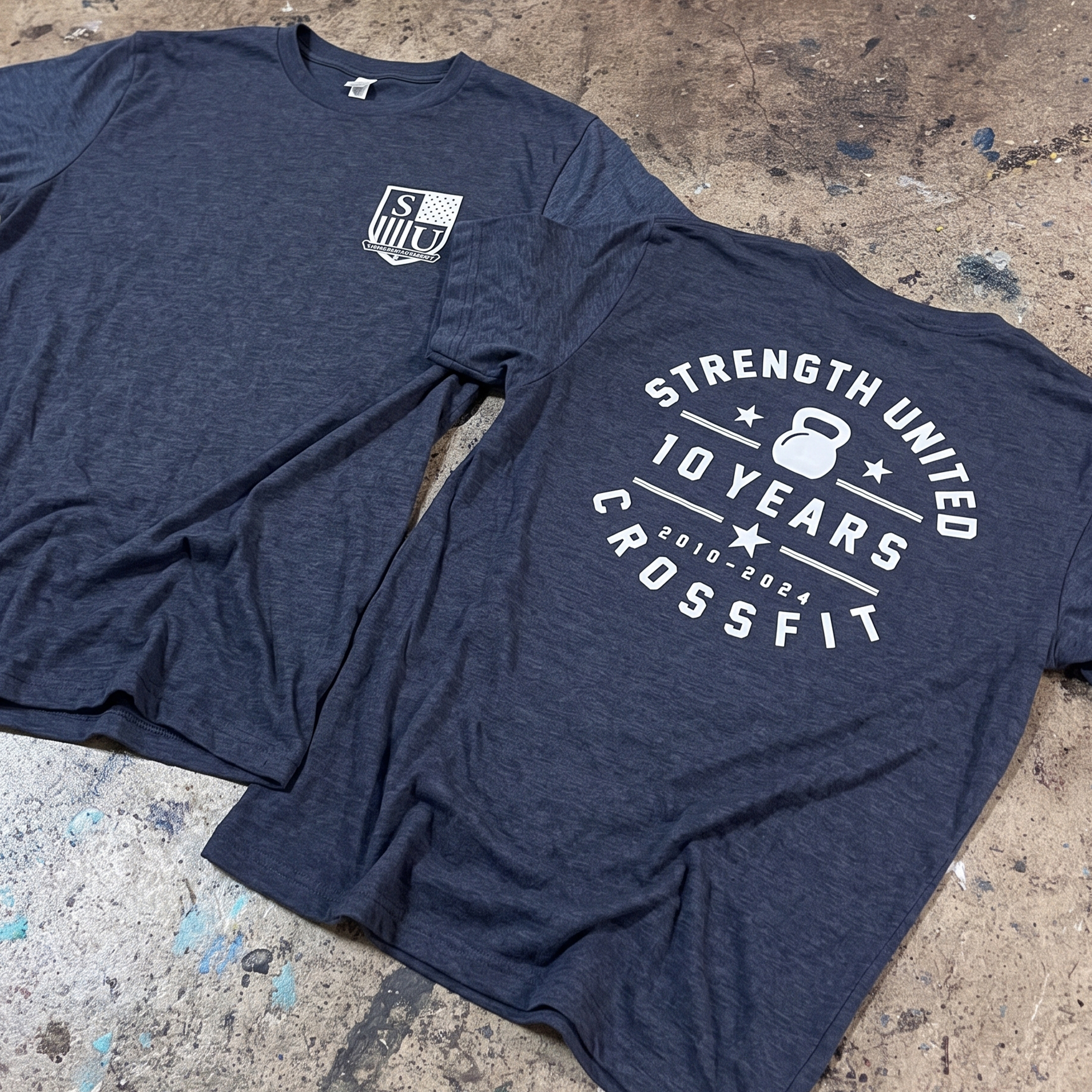 Navy T-shirts with a small crest logo and a white 10-year anniversary back print.
